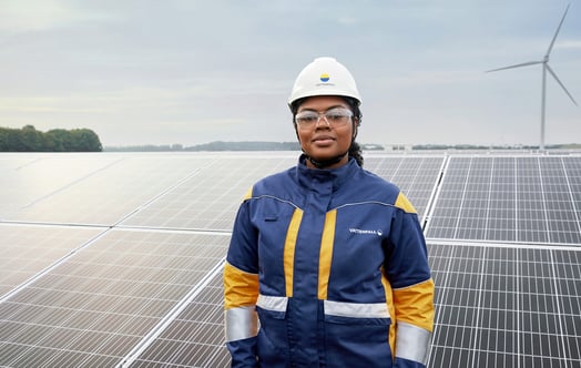 En kvinnelig arbeider med blå krage og hjelm i kombinert energipark. En kvinnelig arbeider med blå krage og hjelm i kombinert energipark.