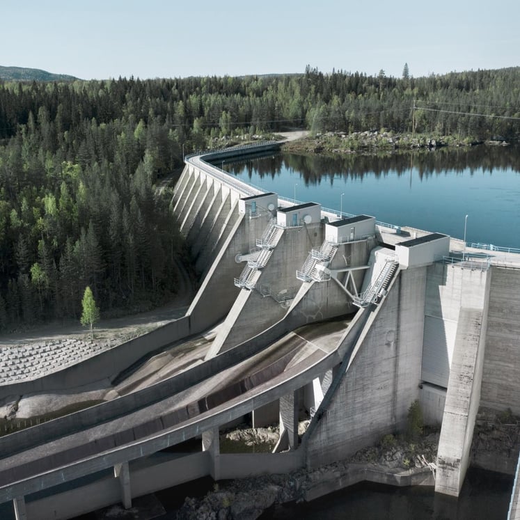 Alt-tekst for det kvadratiske bildet, basert på filnavnet:  Luftfoto av Tuggen kraftstasjon med demning, vannmagasin og skog
